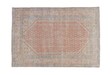 Distressed vintage Serbend rug with a boteh field pattern in faded ruby red, pale blue, and ivory.