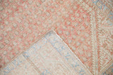 Corner of the vintage Serbend rug showing its hand-knotted back and machine-bound edge.