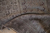 Detail of distressed Qashqai rug runner with worn geometric patterns in fascia and slate gray.