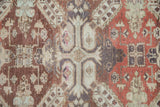 Heavy abrashes and visible knot heads on the central geometric medallion of a distressed vintage rug.