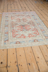 Lengthwise view of a vintage Caucasian rug, showing the abrashed terracotta and denim blue colors.