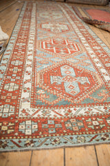 Low angle view along a Karaja runner showing repeating brick red and sky blue medallions.