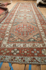 Low perspective of a distressed Karaja runner, showing the full length of its geometric medallions.