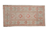 Distressed Oushak runner rug with stepped medallions and floral motifs in soft red, beige, and charcoal.