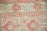 Close-up of the even wear on pinwheel floral motifs and multi-seed borders of the Oushak rug.