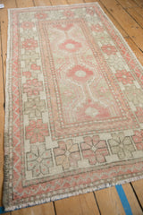 Angled view of a distressed Oushak runner with a column of repeating medallions.