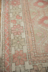 Wide border of a distressed Oushak rug showing simplistic floral motifs and low-pile texture.