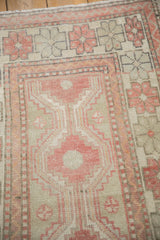 Worn pile texture on the Oushak runner's stepped medallion and geometric floral border.