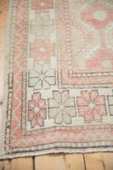 Intricate geometric floral border detail on a distressed Oushak rug with low, even pile.