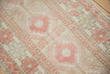 Low-pile texture of a distressed Oushak with pale ruby red and silver geometric motifs.