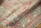 Rolled corner of the vintage Oushak rug, showing the time-softened texture and low, hand-knotted pile.