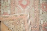 Corner view of a vintage Oushak showing the hand-knotted back and evenly worn pile.