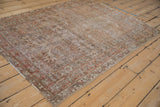 Distressed Mahal rug corner, featuring red floral palmette border, secure fringe, and worn texture.
