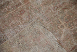 Distressed vintage Mahal rug folded, highlighting low pile, exposed foundation, and muted red motifs.