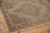 Vintage distressed Senneh rug corner with charcoal border and muted Herati pattern.