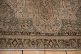 Distressed vintage Senneh rug border with geometric motifs, muted Herati pattern, and machine-bound edge.