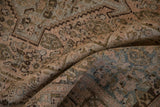 Folded pile of the distressed Senneh rug, showing muted dusty teal and pale sandalwood hues.