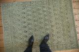 Powder blue boteh motifs and time-softened tones on a distressed vintage Senneh rug.
