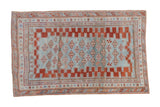 Antique distressed Caucasian rug with light blue field, red geometric guls and stepped border.
