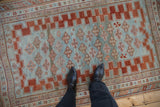 Distressed antique Caucasian rug with quatrefoil guls on an abrashed powder blue field.