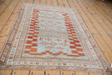 Distressed powder blue field with geometric stepped red border and quatrefoil guls.