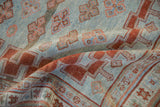 Antique Caucasian rug detail showing powder blue field, cherry red quatrefoil guls, and worn stepped border.