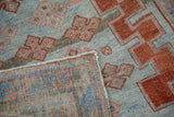 Distressed Caucasian rug corner: low pile, powder blue field, brick red guls, and woven reverse.