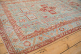 Distressed Persian Malayer rug showing soft powder blue, raspberry red geometric border, and floral motifs.
