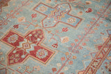 Distressed Malayer rug showing powder blue field with raspberry geometric and floral motifs.