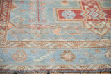Distressed Malayer rug detail: powder blue field, geometric border texture, and fringe.
