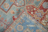 Layers of distressed Malayer rug revealing worn powder blue, raspberry, and sandalwood tones.