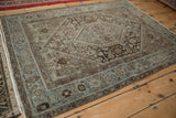 Distressed vintage Northwest Persian rug with dusty powder blue border and visible machine bound side.
