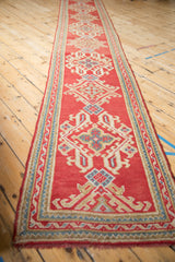 Vintage Oushak runner end, displaying red, ivory, blue geometric border and fringe.