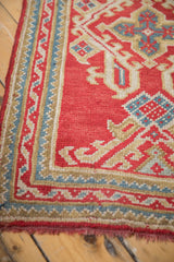 Vintage Oushak runner border detail in cherry red, ivory, sky blue, with secured fringe.