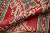 Hand-knotted pile texture of a Vintage Oushak runner, featuring cherry red, ivory, and blue hook and latch motifs.
