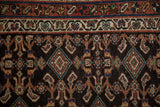 Intricate starburst and vine borders frame the diamond-patterned navy field of an antique Hamadan.