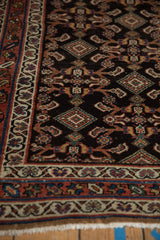 Intricate starburst border and navy Herati field on an antique Persian Hamadan rug runner.