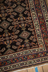 Angled view of a hand-knotted Hamadan runner's corner with intricate Herati and floral designs.