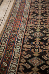Close view of the starburst pinwheel and vine borders on an antique Persian Hamadan runner.