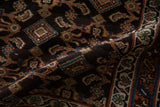 Plush navy blue-black pile of an antique Hamadan rug showing intricate Herati and gul motifs.