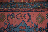 Vintage Mehriban runner with dusty raspberry field, navy cloudband border, and plant motifs.