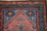 Vintage Mehriban rug corner with faded red, blue borders, bird motif, and blooming pile.