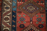 Hooked diamond medallion and pinwheel guls in madder red, sapphire blue, and ivory.
