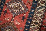 Stylized human and animal figures on the madder red field of an antique Persian runner.