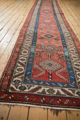A long, angled perspective of the antique Persian runner's interconnected diamond medallions.