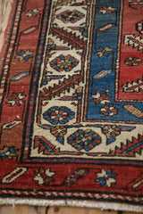 Hand-knotted texture showing low pile and knot heads on the antique Persian runner's corner.