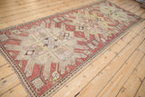 Angled perspective of a distressed Kazak runner showing its large-scale starburst design.