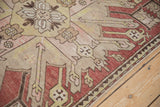 Close view of the even wear and geometric pomegranate motifs on a distressed antique Kazak rug.