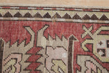 Intact side cord selvage and worn, hand-knotted texture on an antique Kazak rug runner.