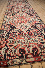 Long antique Karabagh runner showcasing repeating navy, red, and ivory Rococo-style designs.